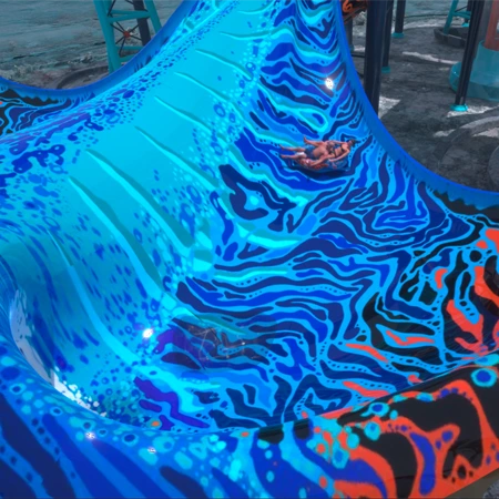 Due persone scendono su un gommone biposto lungo la superficie della manta del complesso di acquascivoli Novatù